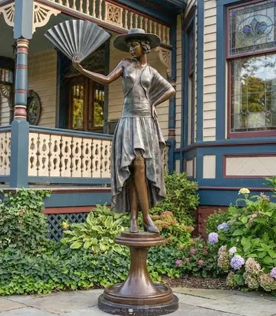 A vintage Lady Standing Holding Fan Bronze Statue